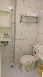 a white bathroom with a toilet and a shower at 逢甲朵拉 in Taichung