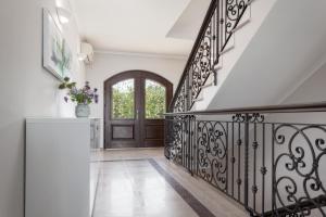 a foyer with a staircase with a wrought iron railing at Luxury apartments Vila Carissa in Malinska