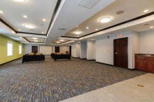 サウスベンドにあるHoliday Inn Express & Suites - South Bend - Notre Dame Univ.のテーブルと椅子が備わる広い客室です。