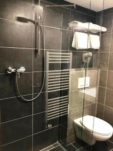 uma casa de banho com um chuveiro e um WC. em Hotel Atrium em Vyškov