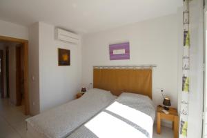 エンプリアブラバにあるApart-rent Apartment Port Salins 0155のベッドルーム1室(木製ヘッドボード付きのベッド1台付)