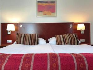 uma cama grande num quarto de hotel com duas lâmpadas em Hotel Atrium em Vyškov