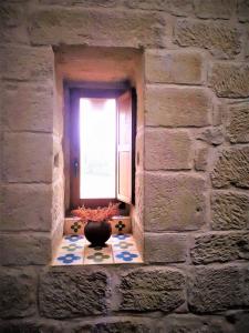 ein Fenster in einer Ziegelmauer mit einer Vase auf einem Tisch in der Unterkunft Casa Rural Medieval Torre Fuerte S.XIII in Baños de Rioja