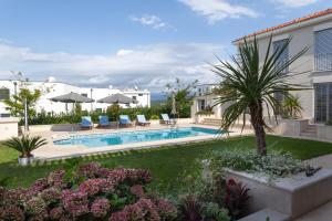 a courtyard with a pool and a palm tree at Luxury Rooms Vila Carissa in Malinska
