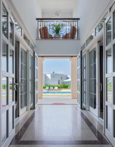 a hallway with glass doors and a view of a pool at Luxury Rooms Vila Carissa in Malinska