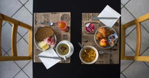 a table topped with bowls of food on a newspaper at 1928 Guest House in Pogno