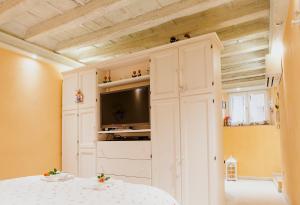 1 dormitorio con 1 cama y TV en una habitación en La Casa degli Uccellini, en Lucca