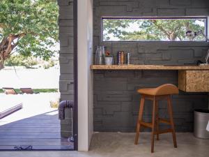 eine Küche mit einer Theke und einem Holzhocker in der Unterkunft The Xcape River Kwai in Kanchanaburi