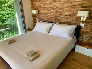 a bedroom with a large bed with two towels on it at La Forestale Luxury Ecolodge B&B Primo Piano in Acqualagna