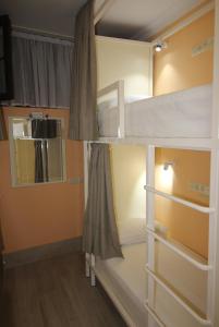 a room with two bunk beds and a mirror at Hostel Jeal in Batumi