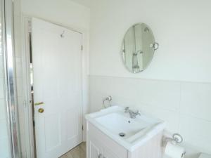 a white bathroom with a sink and a mirror at Elm Villa in Wareham +26 photos