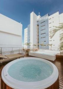 a hot tub on top of a balcony with buildings at Manaíra Apart Hotel in João Pessoa