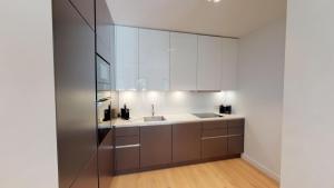 White Pearl Apartment 3.04 في تيميندورفير ستراند: مطبخ مع دواليب بيضاء ومغسلة