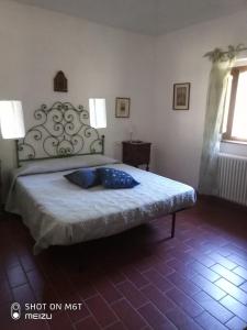Un dormitorio con una cama con una almohada azul. en Podere del Piccini con piscina in val d Orcia Toscana, en Piancastagnaio