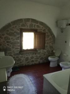 ピアンカスタニャーイオにあるPodere del Piccini con piscina in val d Orcia Toscanaの洗面台、トイレ、窓のあるバスルーム
