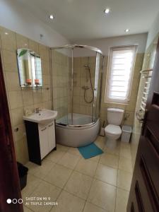 a bathroom with a tub and a toilet and a sink at Domek u Lucy in Rabka-Zdrój