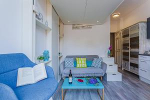 - un salon avec un canapé bleu et une table dans l'établissement MY CASA - 10 CASSINI, à Nice