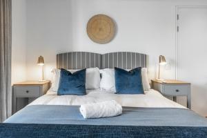 a bedroom with a large bed with blue pillows at 17 Marine - 3Bedroom Sea-Facing Apt101 in Hermanus