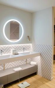 a bathroom with a large mirror and a white tub at Suites Plaza Hotel & Wellness in Andorra la Vella