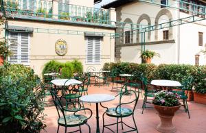 a patio with tables and chairs in a courtyard at Hotel Berchielli in Florence