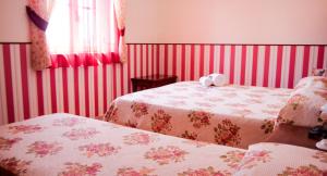 a bedroom with two beds with red stripes at Agriturismo Masseria I Risi in SantʼEufemia Lamezia