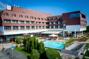 a hotel with a swimming pool in front of a building at Hotel Sopron in Sopron