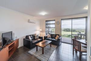 a living room with a couch and a tv at Cosy Corner Sea View Apartments in Albany