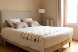 a large white bed with white sheets and pillows at Terres Jaunes in Avenay-Val-dʼOr