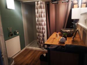 a room with a table and a chair and a curtain at ArT Home Maison d'artiste in Honfleur +4 photos