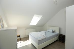 a white bedroom with a bed with a skylight at Joanna Apartment - MA Käfertal in Mannheim