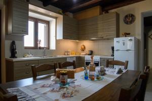 cocina con mesa, sillas y nevera en Villa Valia- Relaxation and Cretan hospitality, en Ierápetra