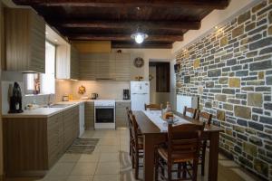 kuchnia ze stołem i ceglaną ścianą w obiekcie Villa Valia- Relaxation and Cretan hospitality w Jerapetrze