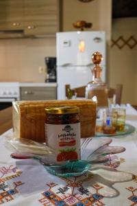 una mesa con un frasco de mermelada y un plato de comida en Villa Valia- Relaxation and Cretan hospitality, en Ierápetra