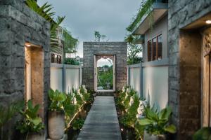 an entrance to a house with a pathway and plants at Ubud Season Villas in Ubud