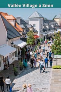 um grupo de pessoas andando por uma rua em uma cidade em J-Mo Home - Magny - Moderne et chaleureux em Magny-le-Hongre