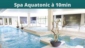 uma piscina num hotel com um spa aquahoaho de beiral infinito em J-Mo Home - Magny - Moderne et chaleureux em Magny-le-Hongre