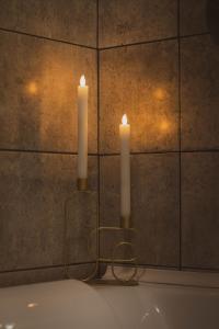 two candles sitting on top of a bath tub at Dream Arena Apartment in Bacău +33 photos