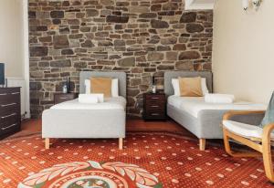 a room with two beds and a brick wall at Three Wells B&B in Llandrindod Wells