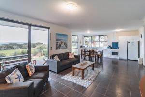 a living room with a couch and a table at Cosy Corner Sea View Apartments in Albany