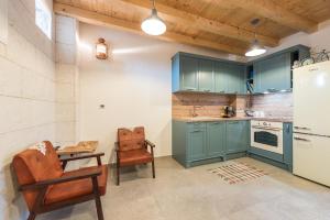 eine Küche mit blauen Schränken, einem Tisch und einem Stuhl in der Unterkunft Holiday Home Lipa Naša in Neviđane