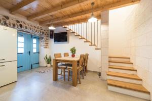 eine Küche und ein Esszimmer mit einem Tisch und einer Treppe in der Unterkunft Holiday Home Lipa Naša in Neviđane
