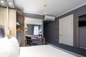 a bedroom with a bed and a desk with a chair at Holiday Inn - Glasgow - City Ctr Theatreland, an IHG Hotel in Glasgow