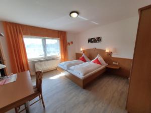 a bedroom with a bed and a desk and a window at Gästehaus Ermen in Kamp-Lintfort
