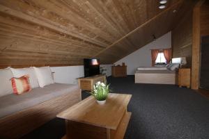 a room with two beds and a wooden ceiling at Hotel Seidl in Straßlach-Dingharting