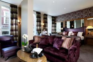 a living room with a couch and a bed at Macdonald Windsor in Windsor