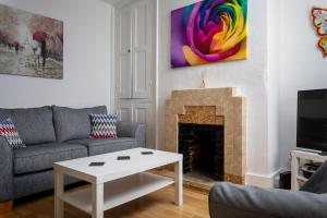 a living room with a couch and a fireplace at Market Street 5 min walk to town centre in Cheltenham