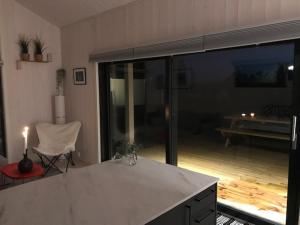 a kitchen with a table and a chair in a room at Hytte med sjøutsikt og 20 min fra dyreparken in Grimstad