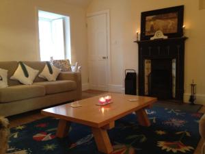 a living room with a coffee table and a fireplace at Quaint and Quirky Cottage in Port Ellen in Port Ellen