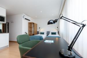 a hotel room with a bed and a desk with a lamp at Feel Corporate Housing Marquês in Porto