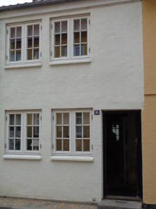 a white building with windows and a door at Dejligt lille byhus in Fåborg